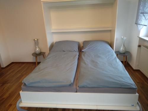 a bed in a room with two tables at Ferienwohnung Ries in Nördlingen