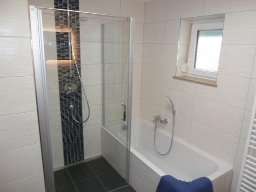 een badkamer met een douche en een bad met een glazen deur bij Ferienwohnung Ries in Nördlingen