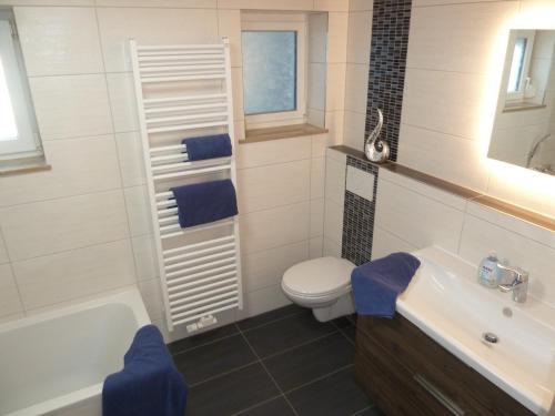 een badkamer met een toilet, een bad en een wastafel bij Ferienwohnung Ries in Nördlingen