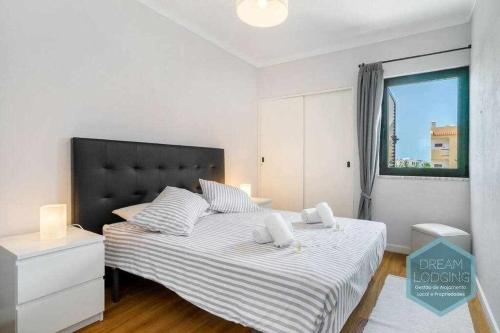 um quarto com uma cama grande e uma cabeceira preta em Forte 303 Dream Lodging em Albufeira
