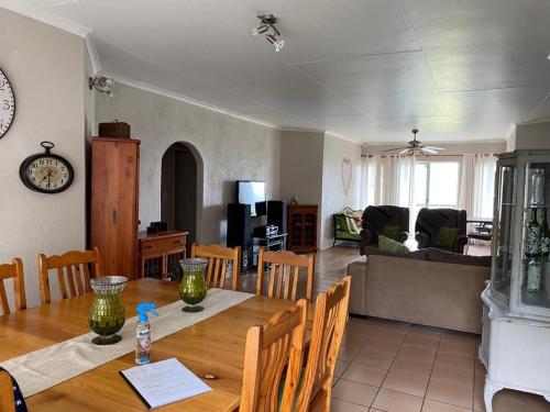 a dining room and living room with a wooden table at La Prima Casa in Graskop