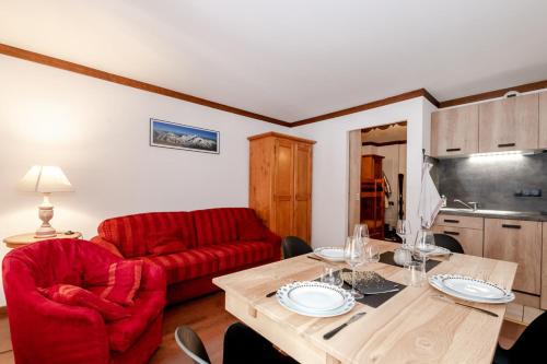 a living room with a red couch and a table at Family Apt With Superb View On The Mont Blanc in Les Houches
