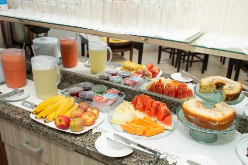um buffet com muitos tipos diferentes de frutas e sumos em Recife Palace Hotel em Parauapebas