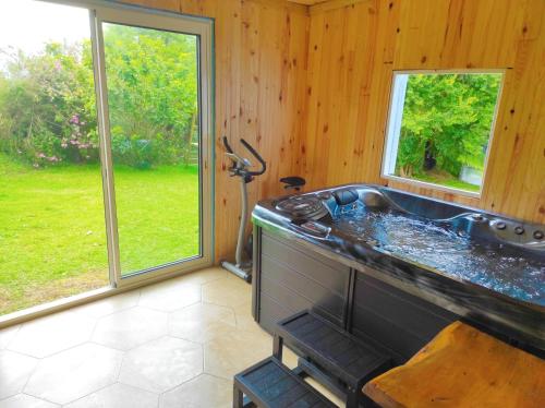 eine Whirlpool-Badewanne in einem Zimmer mit Fenstern in der Unterkunft La Villa Des O, sentier Grand Bassin in La Plaine des Cafres