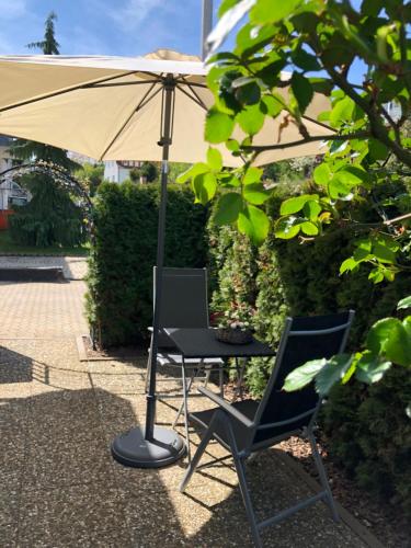 a table and two chairs under an umbrella at Gästehaus Cramer in Bad Kissingen