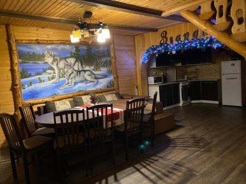 a dining room and kitchen with a wolf painting on the wall at Villa Zgarda1 in Mykulychyn