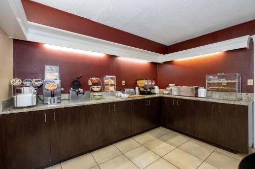a kitchen with brown cabinets and a counter at Red Roof Inn Knoxville North - Merchants Drive in Knoxville