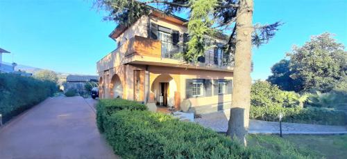 un edificio con un árbol al lado de una calle en Villa Etna, en Viagrande