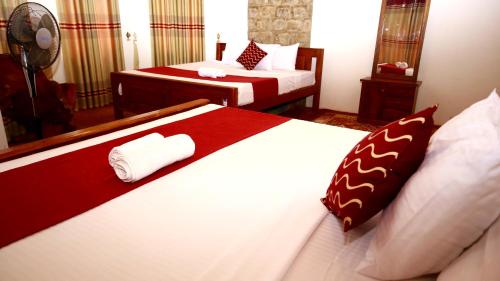 Habitación de hotel con 2 camas y espejo en Kaloogala Scenic Bungalow, en Ella
