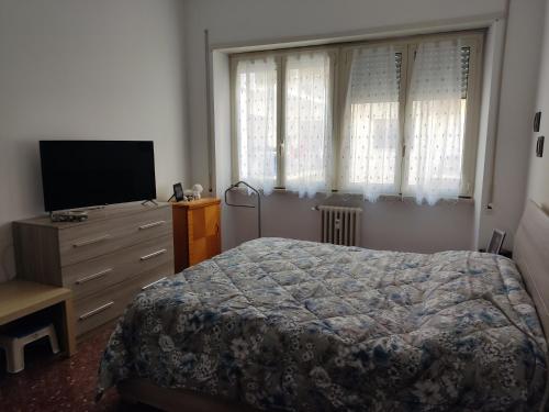 a bedroom with a bed and a dresser with a television at Distretto 14 in Rome