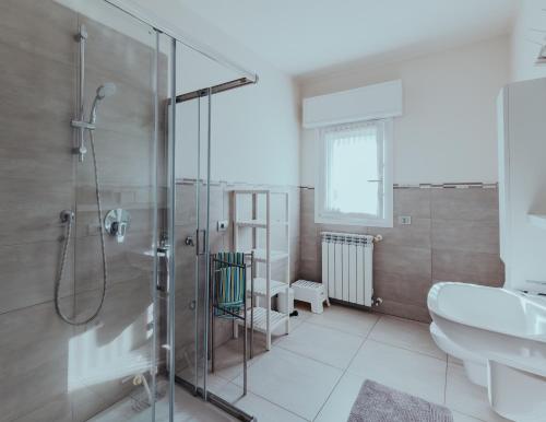 y baño con ducha acristalada y lavamanos. en The Attico, en Padenghe sul Garda
