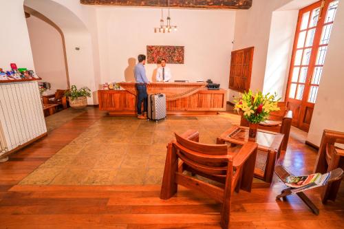 two people standing at the counter of a salon at Hotel Villa Antigua in Sucre