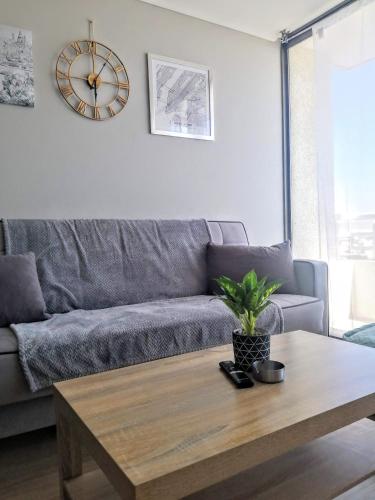 a living room with a couch and a table with a clock at 2 Torres Calama in Calama