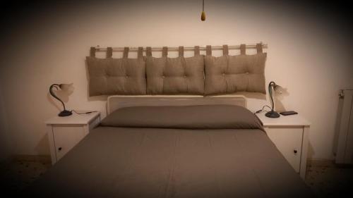 een slaapkamer met een groot bed met 2 nachtkastjes bij Appartamento La Fortezza in Livorno