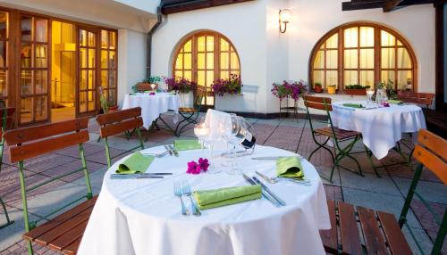 a group of tables with white tablecloths and napkins at Hotel Concertino Zlatá Husa in Jindrichuv Hradec