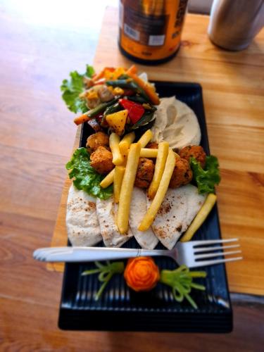 a plate of food with a sandwich and french fries at The Hillside in Kasol
