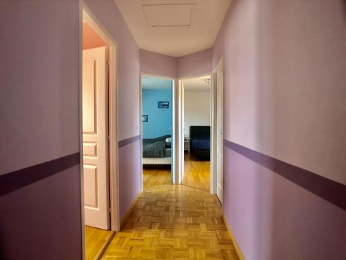 an empty hallway with purple walls and a bedroom at Family Home - Aux portes de l'Histoire in Tour-en-Bessin