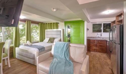 a bedroom with a bed and a kitchen with green curtains at Mansion Dubai-Mountain-Jacuzzi-4BR-Jamaca De Dios in Jarabacoa