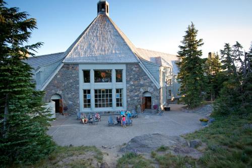 um grande edifício com pessoas sentadas em cadeiras em frente em Timberline Lodge em Government Camp