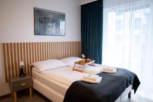 1 dormitorio con 1 cama con 2 toallas en Maya's Flats & Resorts 41 - Walowa 25 F 25, en Gdansk