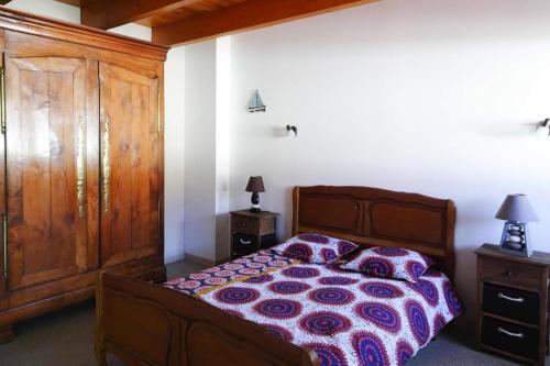 1 dormitorio con 1 cama y armario de madera en Cottage, Guerlesquin en Guerlesquin