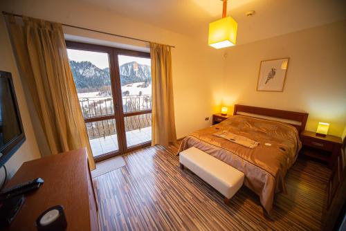 a bedroom with a bed and a large window at Apartamenty Nad Dunajcem in Szczawnica