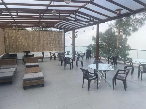 a patio with tables and chairs and a table and chairs at The Golden Sunrise Hotel in Nainital