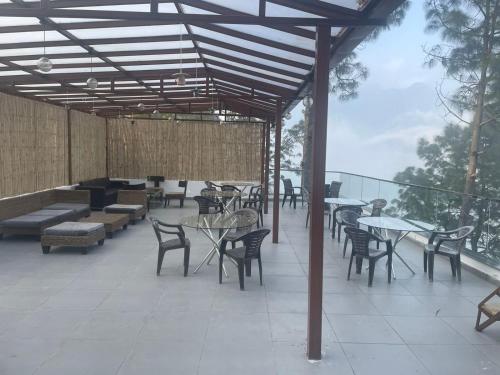 an outdoor patio with tables and chairs and tables and chairs at The Golden Sunrise Hotel in Nainital