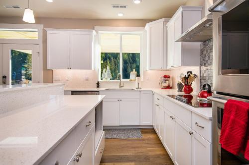 a white kitchen with white cabinets and a window at Leavenworth Farmhouse in Leavenworth