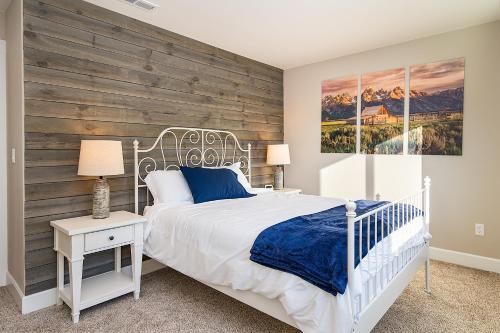 レブンワースにあるLeavenworth Farmhouseの白いベッドと木製の壁が備わるベッドルーム1室が備わります。