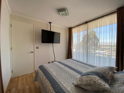 1 dormitorio con cama y ventana grande en Departamento Céntrico Full equipado, en Copiapó