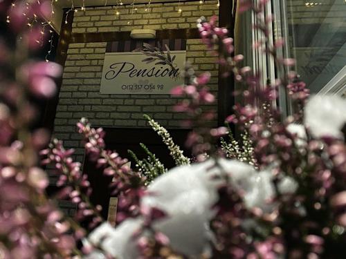 a bunch of pink flowers in front of a sign at Pension Lavendel in Harztor