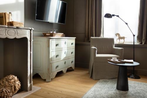 a living room with a dresser and a chair at Mansion9Bruges in Bruges