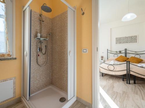 a bathroom with a walk in shower next to a bed at Villa Chiara Solanas in Solanas