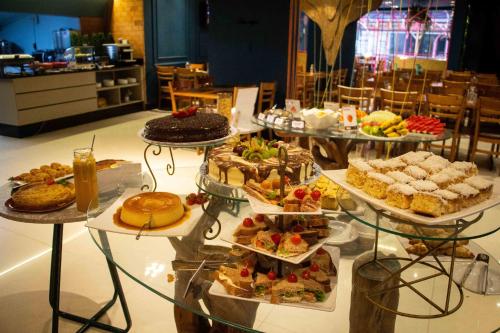 a buffet of different types of cakes and pastries at Camboriú Praia Hotel in Balneário Camboriú