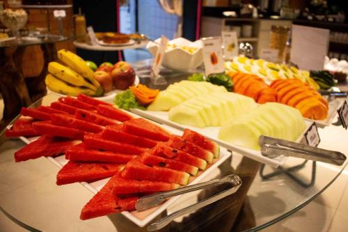 a buffet of fruits and vegetables on a glass table at Camboriú Praia Hotel in Balneário Camboriú