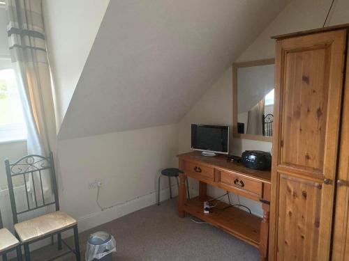 a bedroom with a desk with a tv and a mirror at The Curragh Country House Accommodation in Newbridge