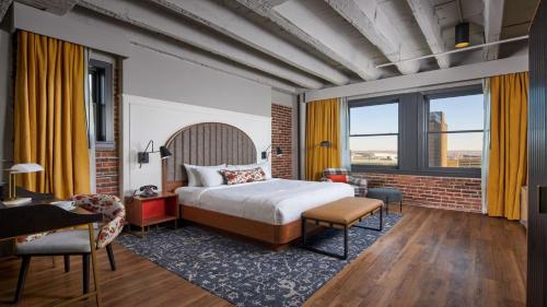 オマハにあるHotel Indigo - Omaha Downtown by IHGのベッドと机があるホテルの部屋