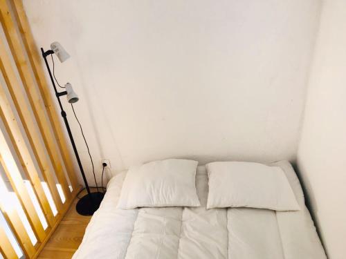 a bed in a small room with a lamp at Estudio do Loureiro in Vidigueira