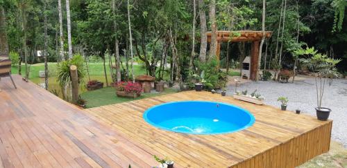 a wooden deck with a blue swimming pool on top of it at Recanto Della Mata in Venda Nova do Imigrante