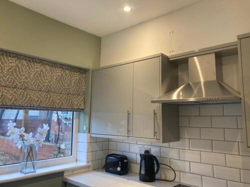 a kitchen with a sink and a microwave and a window at Alexandra House in Goole