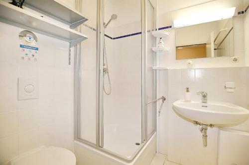 a bathroom with a shower and a sink and a toilet at Haffblick Wohnung 43 in Boltenhagen