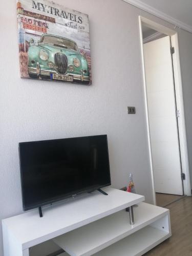 a flat screen tv sitting on top of a white entertainment center at 2 Torres Calama in Calama