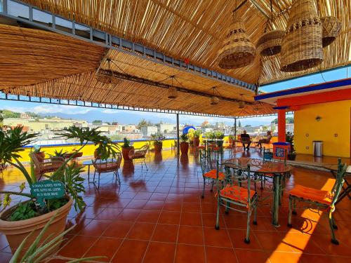 ein Restaurant mit Tischen und Stühlen und Aussicht in der Unterkunft Hotel Suites Del Centro in Oaxaca de Juárez