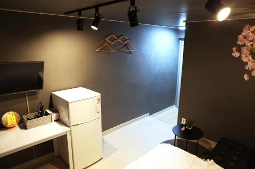 a room with a refrigerator and a tv on a wall at Ellen House in Seoul