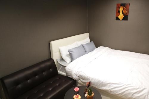 a bedroom with a bed and a chair and a table at Ellen House in Seoul