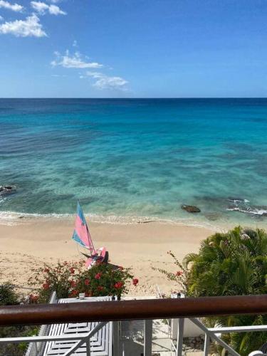 a view of a beach with an umbrella and the ocean at Bianca Bay 3 Bedroom West Coast Beach Front Villa in Saint James