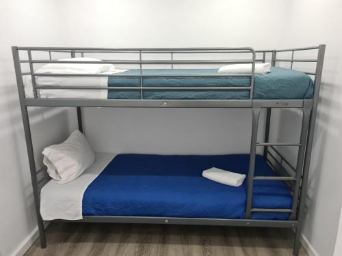 Etagenbett mit blauer Bettwäsche und blauer Matratze in der Unterkunft Casa do Mestre in Setúbal