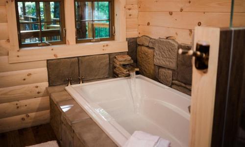 a bathroom with a large tub in a cabin at Treehouse #3 by Amish Country Lodging in Millersburg