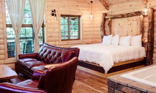 een slaapkamer met een bed, een bank en een bad bij Treehouse #4 by Amish Country Lodging in Millersburg